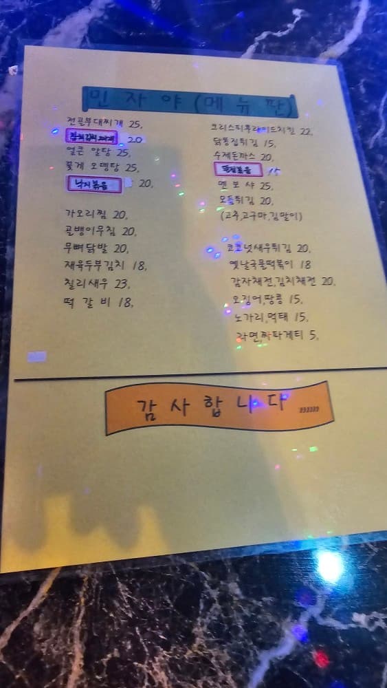 부산 거제동 민자야 포차의 노란색 손글씨 메뉴판. 다양한 안주와 식사 메뉴로 혼술하기 좋음.