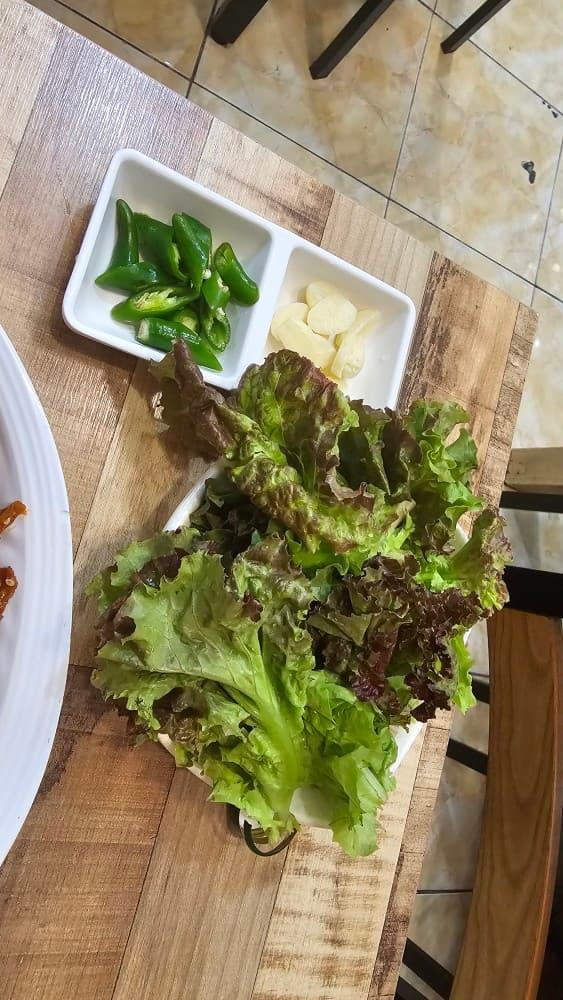 밤샘포차의 신선한 상추 쌈과 마늘, 고추, 혼술 안주에 곁들이기 좋은 정갈한 기본 상차림.