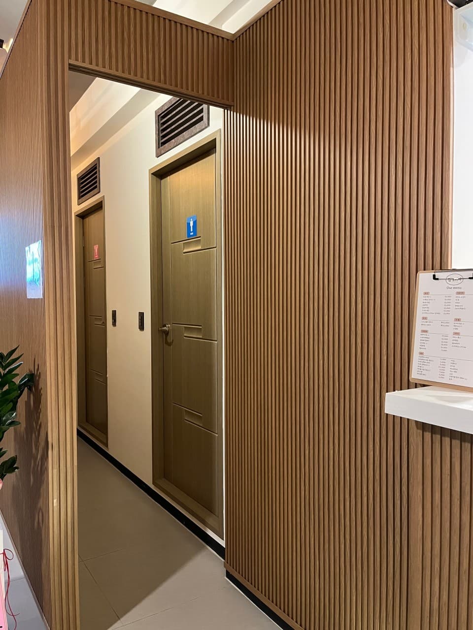 김스비어의 깔끔한 우드톤 인테리어가 돋보이는 화장실 입구와 메뉴판. 혼술하기 좋은 쾌적하고 아늑한 분위기의 호프집 내부.