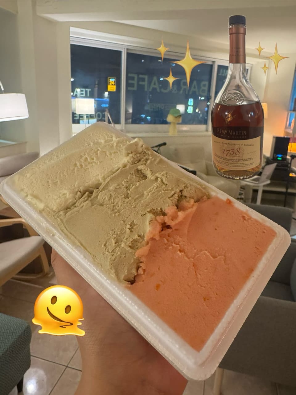 흰색 사각 용기에 담긴 삼색 아이스크림과 배경에 놓인 양주병 및 창밖 야경이 보이는 1인 좌석