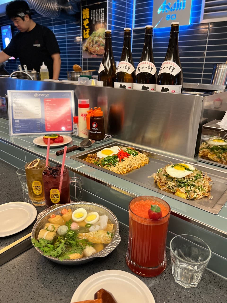 철판 위 오코노미야키와 야키소바, 하이볼과 오뎅탕이 차려진 주방 앞 1인용 카운터 테이블