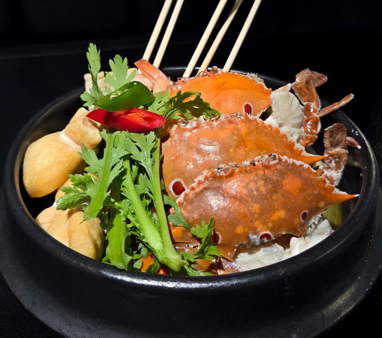 세종특별자치시 보듬3로 요리주점 랑 세종 다찌석 1인 혼술 상황. 검은 뚝배기에 담긴 꽃게와 어묵 꼬치, 유부 주머니의 질감이 조명 아래 강조됨.