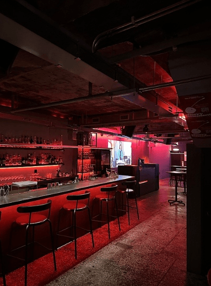 부산광역시 동구 맥주 호프 체리베이스먼트 - 붉은 네온 조명 아래 긴 다찌석과 높은 의자가 배치된 1인 혼술 공간