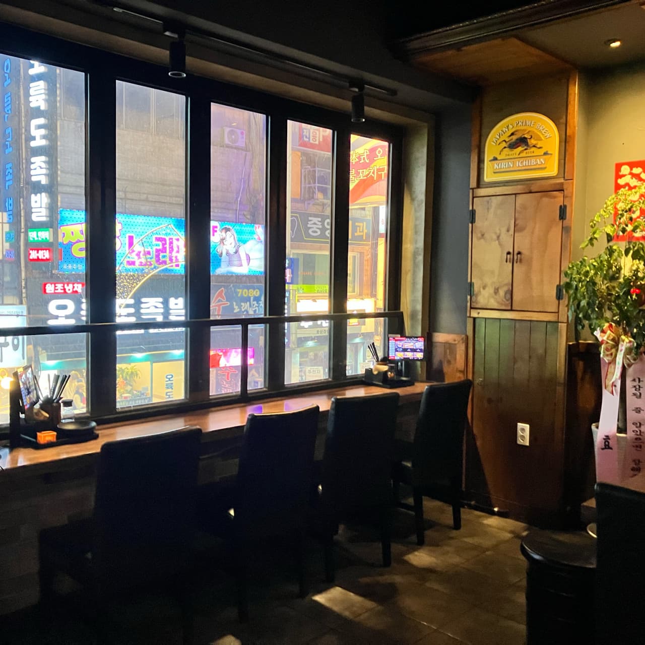 부산광역시 중구 요리주점 히노카오뎅 남포점의 창가 1인 다찌석. 도시 네온사인 야경을 배경으로 혼술 가능한 테이블 오더 좌석 구성.