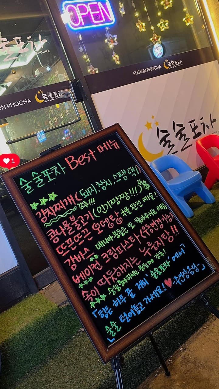 인천광역시 서구 술술포차 인천서구청 입구. 네온사인 아래 김치찌개와 감바스 등 메뉴가 적힌 칠판이 놓여 있으며 1인 혼술이 가능한 포차 외부 전경.