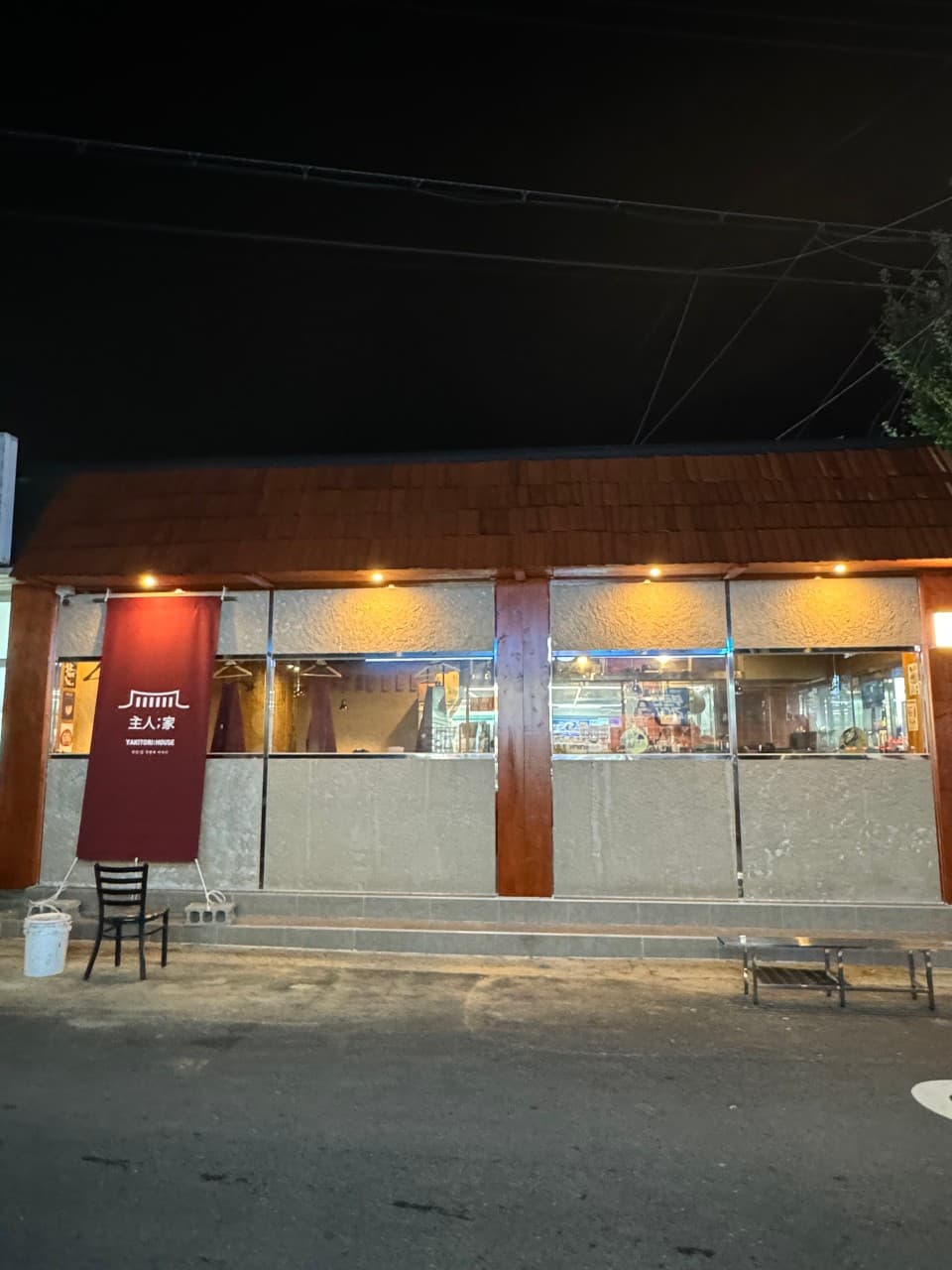 경상남도 진주시 이자카야 주인집 하대본점 진주 노란 조명 아래 붉은 천막과 창문 너머 혼술 전용 다찌석이 보이는 목재 건물 외부 전경