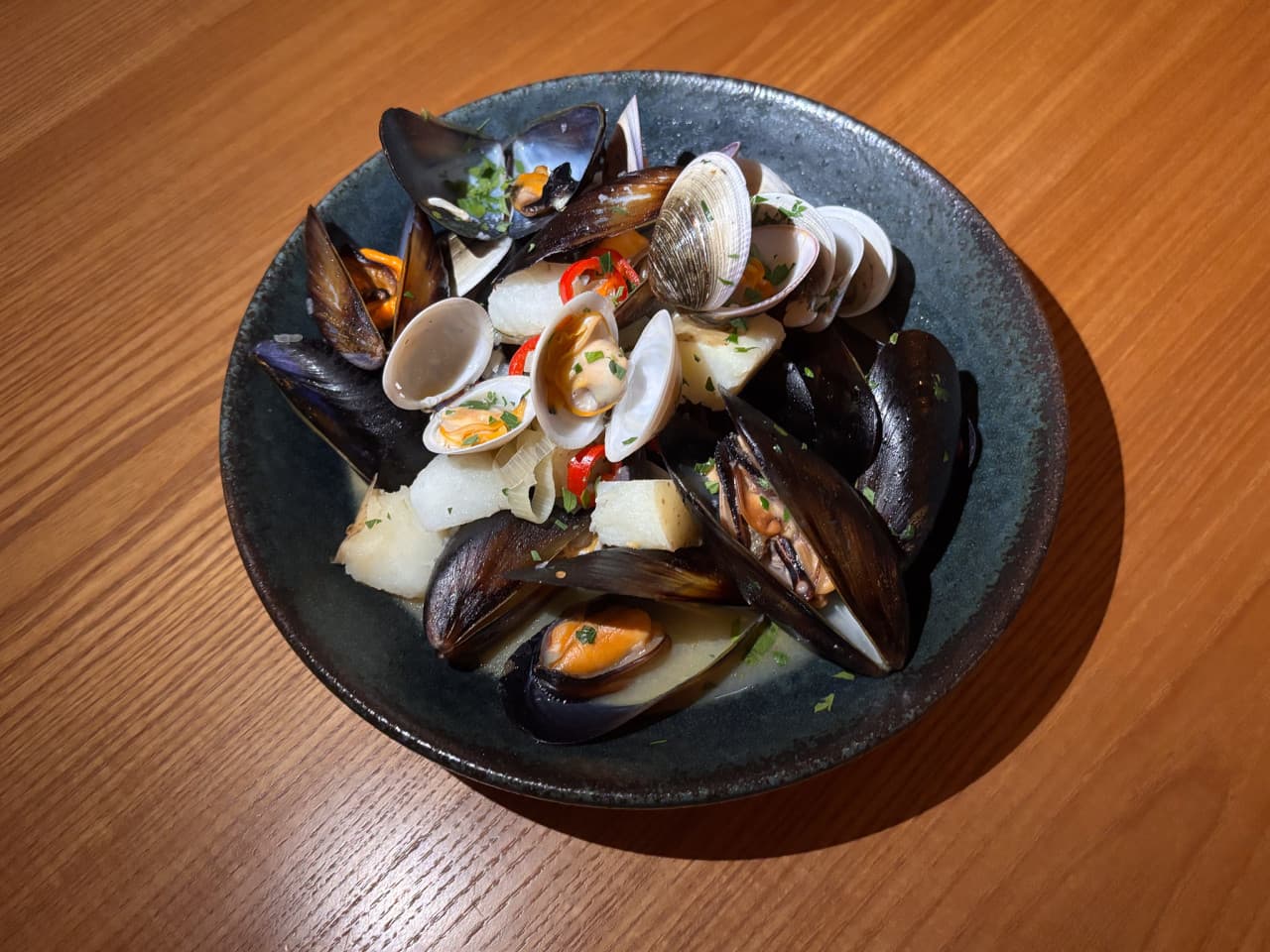 서울특별시 송파구 요리주점 디에스티클럽 석촌 나무 다찌석 조명 아래 1인 혼술 메뉴로 차려진 홍합 조개찜과 해산물 요리 구성