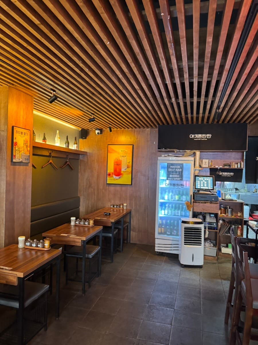 서울특별시 송파구 혼술 이자카야 야키톤탄탄 잠실 - 우드 슬랫 천장과 핀 조명 아래 배치된 1인 다찌석과 테이블