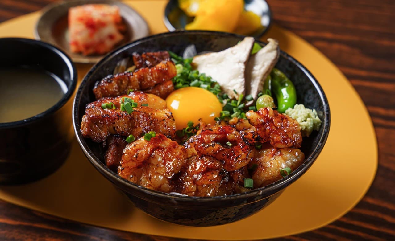 대전광역시 서구 마포십번 대전서구 이자카야 다찌석 1인 혼밥. 노란 조명 아래 윤기 흐르는 대창과 달걀 노른자가 올라간 덮밥, 장국, 반찬이 놓인 상차림.