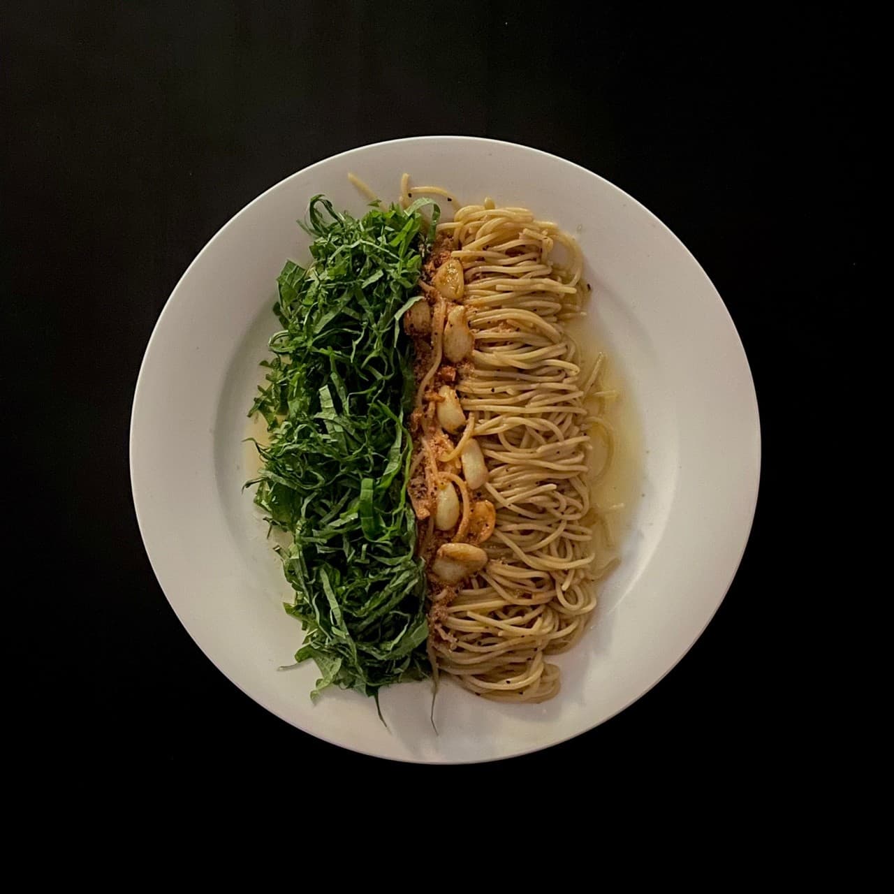 대전광역시 서구 심도 대전서구 요리주점의 다찌석 1인 파스타. 어두운 조명 아래 흰 접시에 담긴 깻잎과 마늘 면 요리로 혼밥 및 혼술 상황을 보여줌.