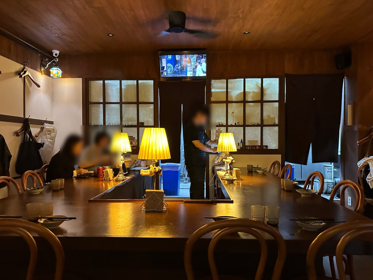 대전광역시 중구 요리주점 연남 대전 대흥동의 ㄷ자형 다찌석과 노란 스탠드 조명. 혼술을 위한 1인 좌석이 배치된 목재 마감의 내부 공간 상황.