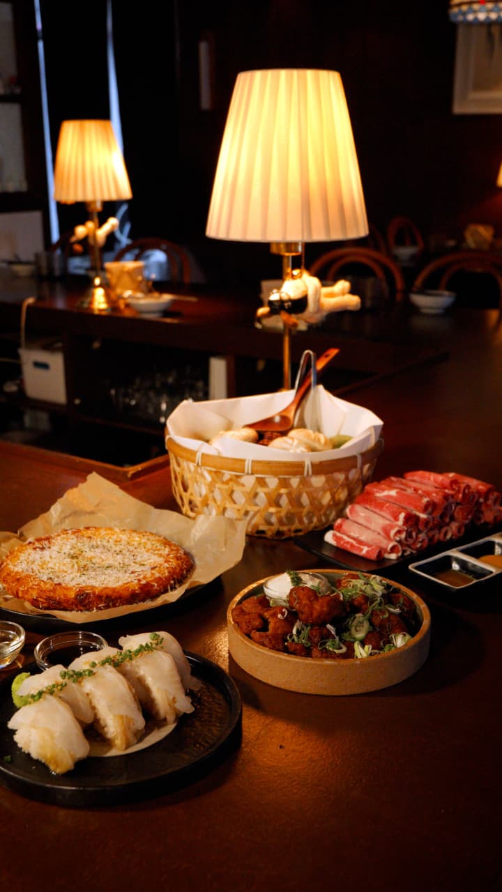 대전광역시 중구 요리주점 연남 대전 대흥동의 다찌석에서 노란 조명 아래 선홍빛 소고기와 바삭한 튀김을 차려놓고 즐기는 1인 혼술 상황.