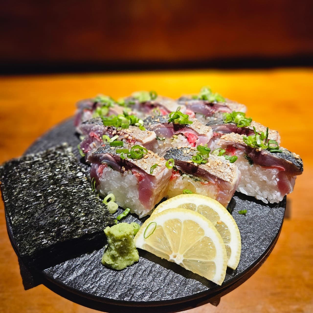서울특별시 강남구 이자카야 고코 강남신논현점 다찌석 조명 아래 김과 레몬, 와사비를 곁들여 차려진 1인 혼술 메뉴 고등어 봉초밥