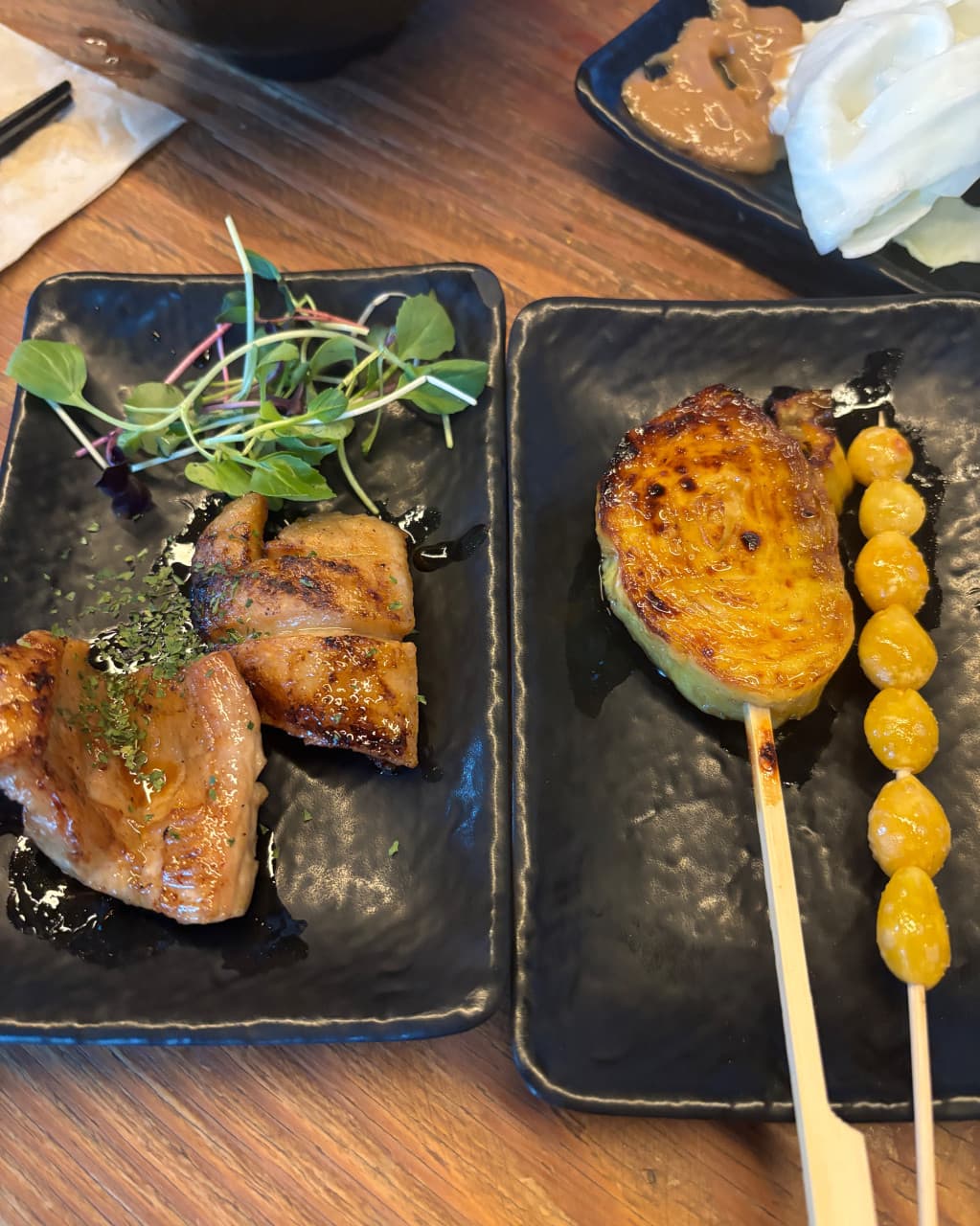 대구광역시 달서구 이자카야 토리아에즈 상인동 대구점 다찌석 혼술. 나무 테이블 위 검은 접시에 담긴 닭꼬치와 은행 꼬치 구이, 된장 소스를 곁들인 양배추 차림.