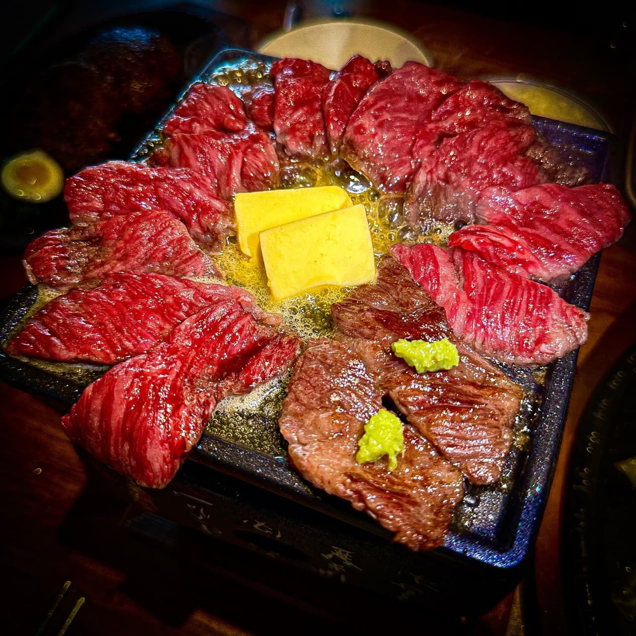 서울특별시 강남구 쿄코코 신논현 이자카야 다찌석 조명 아래 1인 화로에서 익어가는 소고기와 버터. 혼술 상황에 맞춰 돌판 위에 나란히 놓인 선홍빛 육류의 질감과 생와사비.