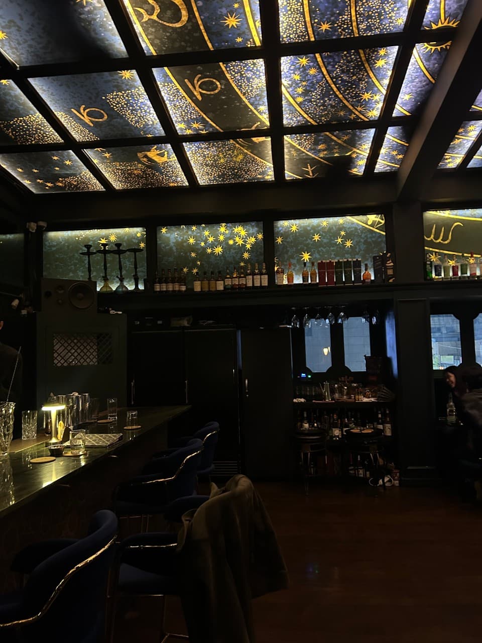 서울특별시 강남구 어글리 강남 바(Bar) 별자리 천장 조명 아래 1인 다찌석과 파란 의자가 배치된 공간에서 즐기는 혼술