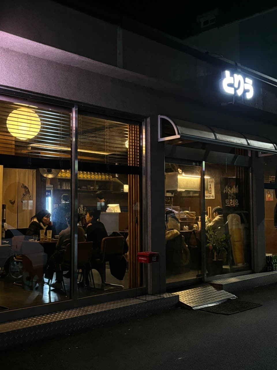 경상북도 경주시 이자카야 토리우 경주 - 노란 둥근 조명이 켜진 밤 다찌석과 통유리 너머 혼술을 위한 1인석이 마련된 실내