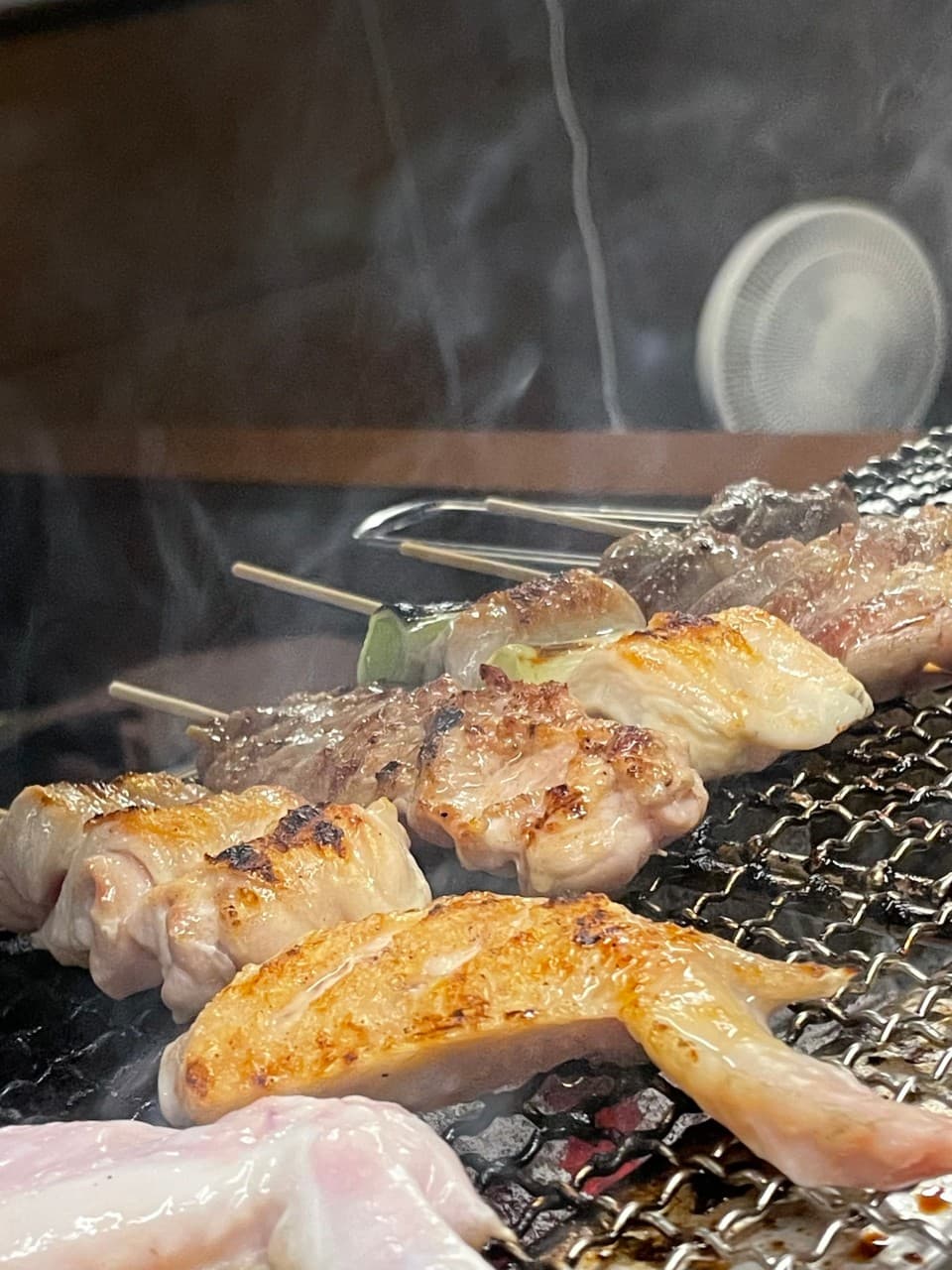 경상북도 경주시 이자카야 토리우 경주 - 석쇠 위에서 연기가 피어오르며 노릇하게 구워지는 닭꼬치와 1인 다찌석 혼술 상황