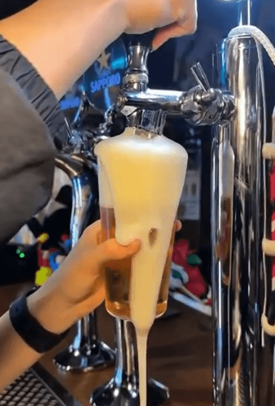 대구광역시 중구 교동 서서 대구 맥주 호프 다찌석 1인 혼술 상황. 맥주 탭에서 잔으로 추출되어 흐르는 흰 거품의 질감과 어두운 실내 조명 아래 금속제 탭 타워 배치.