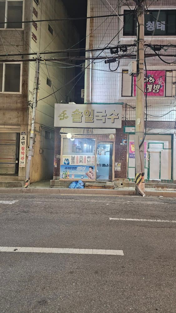 부산광역시 동구 솔잎국수 초량 실내 포장마차 - 밤거리 밝은 조명 아래 1인 다찌석이 들여다보이는 매장 전경으로 혼술과 혼밥을 즐기는 분위기