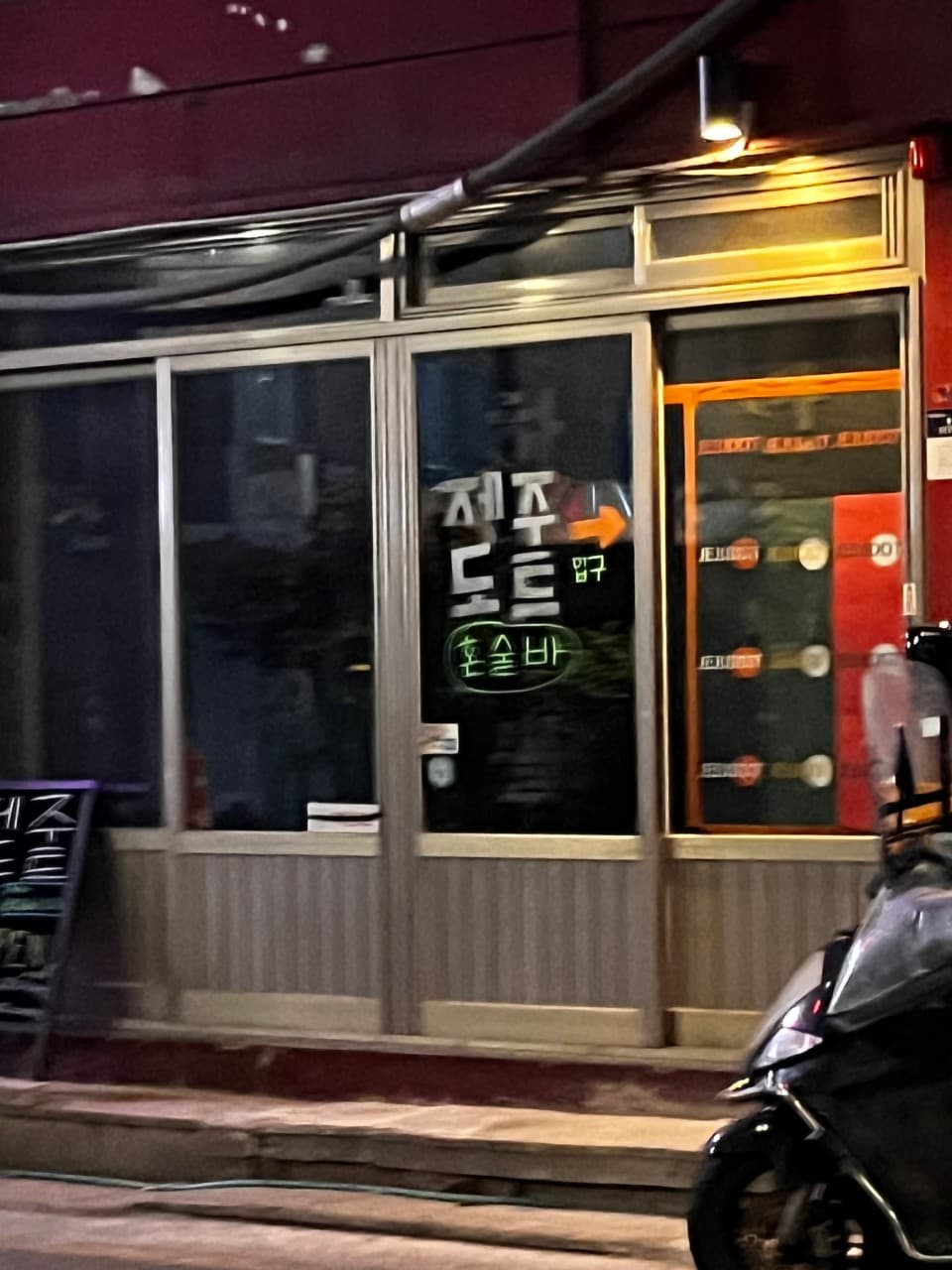 경기도 의정부시 제주도트 혼술바 의정부점 입구. 밤 조명 아래 유리문에 혼술바 문구와 화살표가 붙은 바(Bar) 외관. 내부 다찌석이 보이는 1인 중심의 공간.