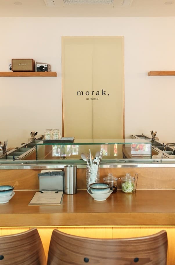 경기도 안양시 모락, 경기 안양 혼술 공간. 목재 다찌석과 1인 좌석, 간접 조명 아래 스테인리스 오뎅 조리대와 식기가 놓인 기타 주점 내부.
