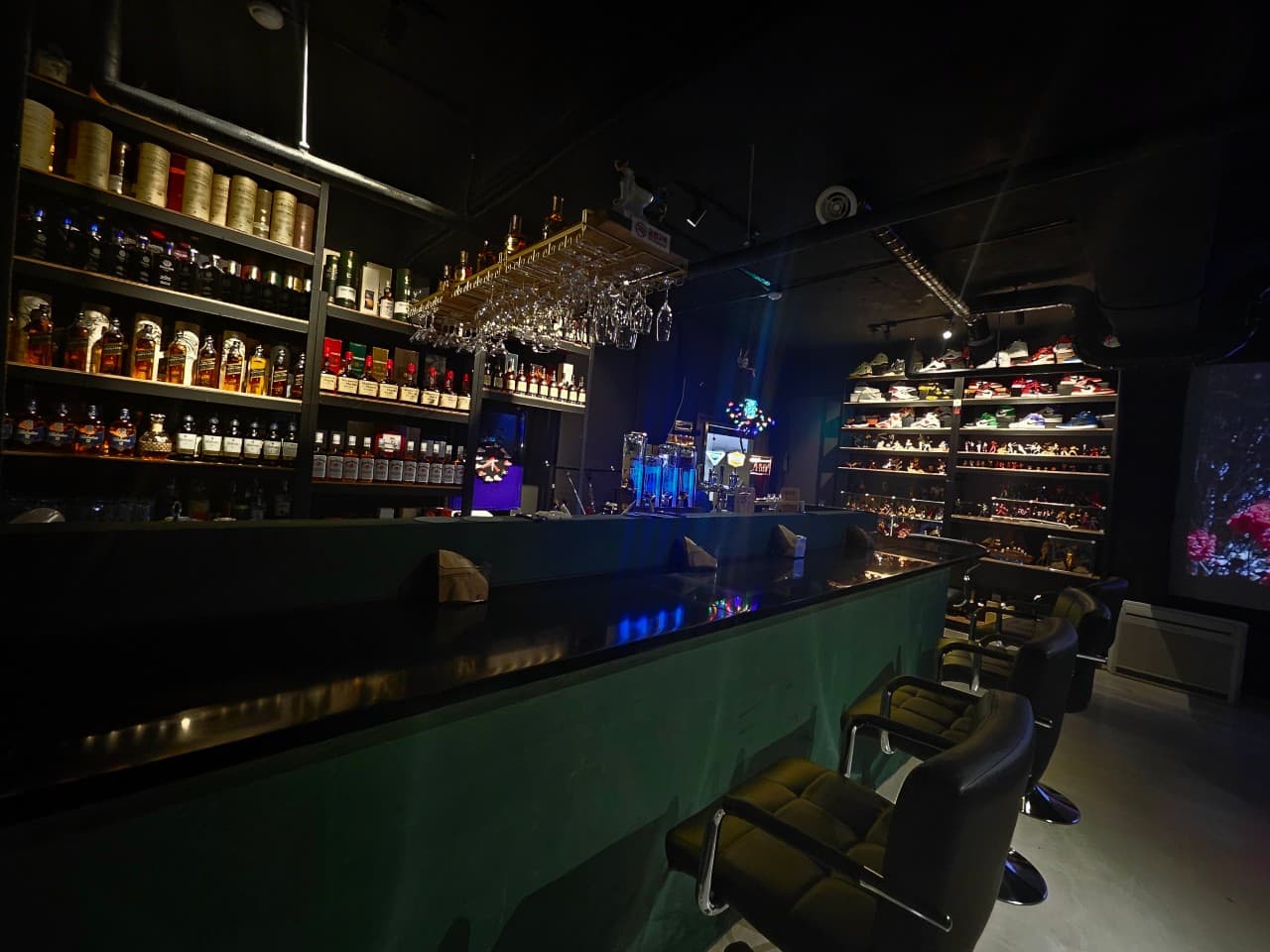 경기도 성남시 JANA BAR & PUB 바(Bar) - 푸른 조명 아래 긴 다찌석과 위스키 병, 스니커즈 진열장이 배치된 1인 혼술 공간