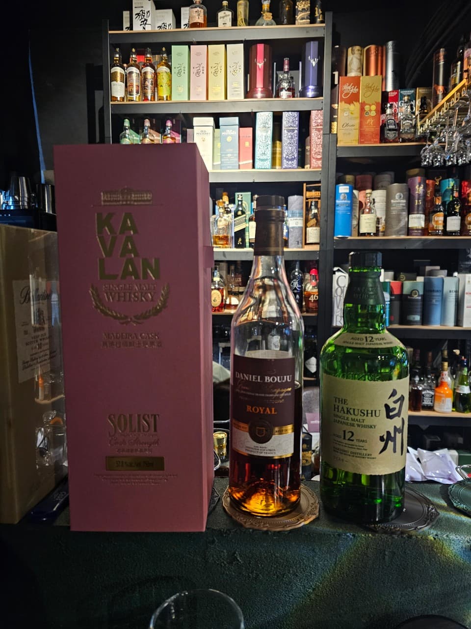 경기도 성남시 JANA BAR & PUB 바 카운터석에 놓인 카발란과 하쿠슈 위스키. 조명이 집중된 1인 다찌석에서 즐기는 혼술 상황과 배경의 정렬된 술병들.