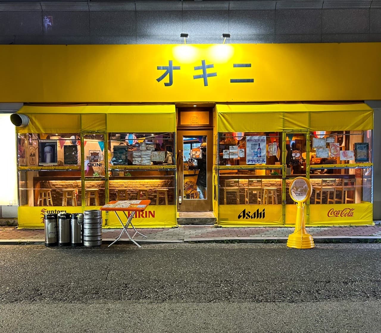 전남광주통합특별시 목포시 이자카야 오키니 전남의 노란 외관과 1인 다찌석. 주황색 조명이 켜진 실내 창가 좌석과 외부의 맥주통이 배치된 혼술 상황.