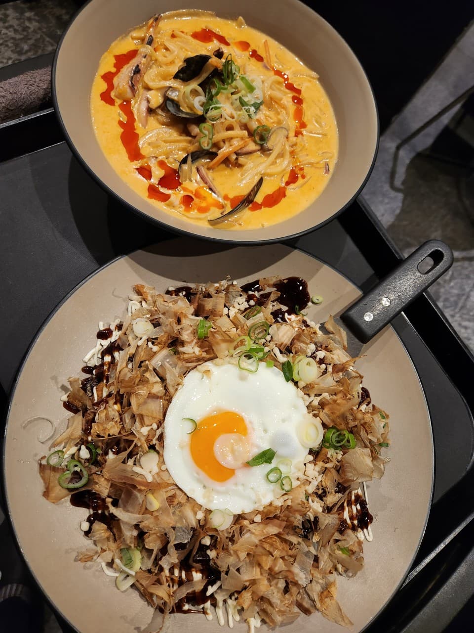 전남광주통합특별시 순천시 요리주점 아스라이 조례점 순천 다찌석 혼술. 주황색 해물 크림 면 요리와 가쓰오부시 위 계란후라이가 올라간 오코노미야키가 담긴 어두운 톤의 1인 테이블.