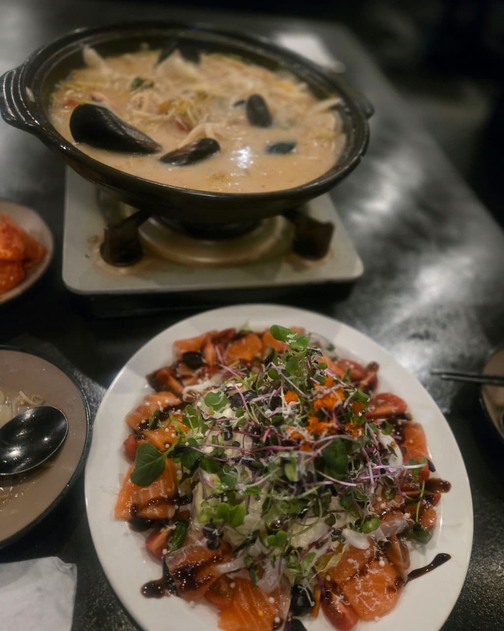 전남광주통합특별시 순천시 요리주점 아스라이 조례점 순천 - 조명 아래 다찌석에서 혼술로 즐기는 연어 샐러드와 홍합 크림 나베