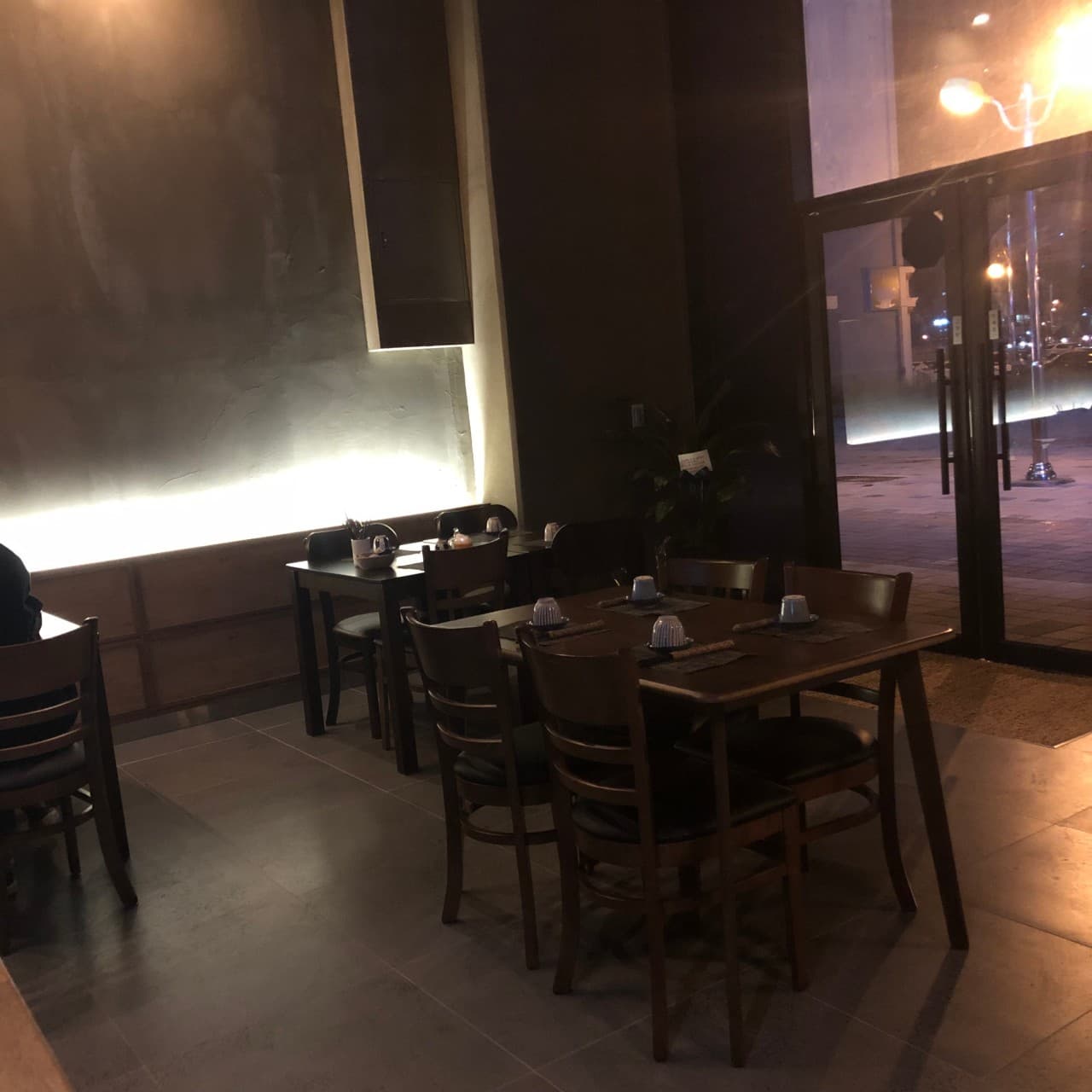 전남광주통합특별시 무안군 이자카야 남악은파 전남 - 간접 조명이 비추는 목재 테이블과 1인 다찌석이 배치된 어두운 톤의 혼술 공간