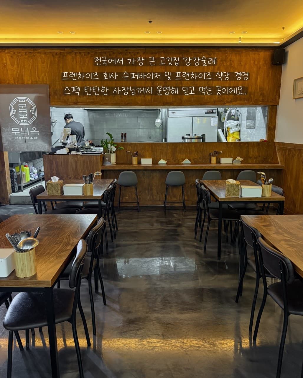 전남광주통합특별시 서구 요리주점 무늬옥 전남 - 주황색 간접 조명 아래 목재 다찌석과 1인 좌석이 배치된 혼술 공간. 오픈 주방 앞 바 테이블과 정갈한 테이블 세팅.