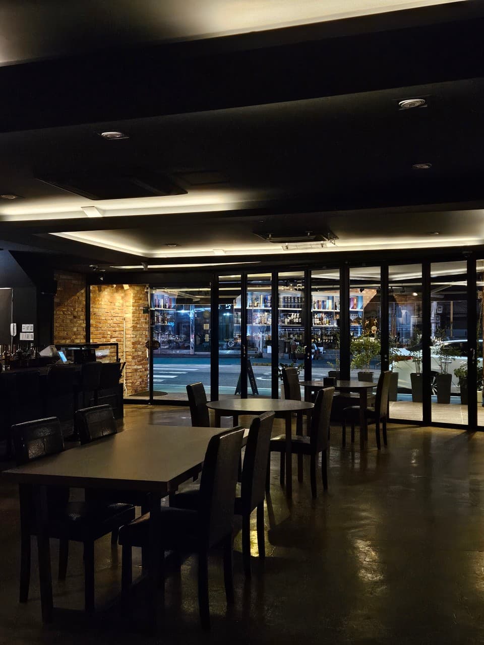 전남광주통합특별시 목포시 밀물 전남 바(Bar) 내부. 간접 조명이 비치는 다찌석과 원형 테이블이 배치된 공간에서 혼술을 즐기는 상황을 보여줌.
