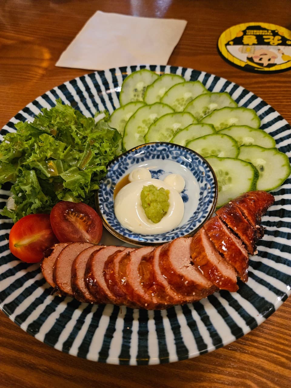 세종특별자치시 나성북1로 타키 세종나성점 나무 다찌석의 1인 혼술 차림. 노릇하게 구운 명란과 얇은 오이, 마요네즈 소스가 조명 아래 놓인 기타 안주 요리.