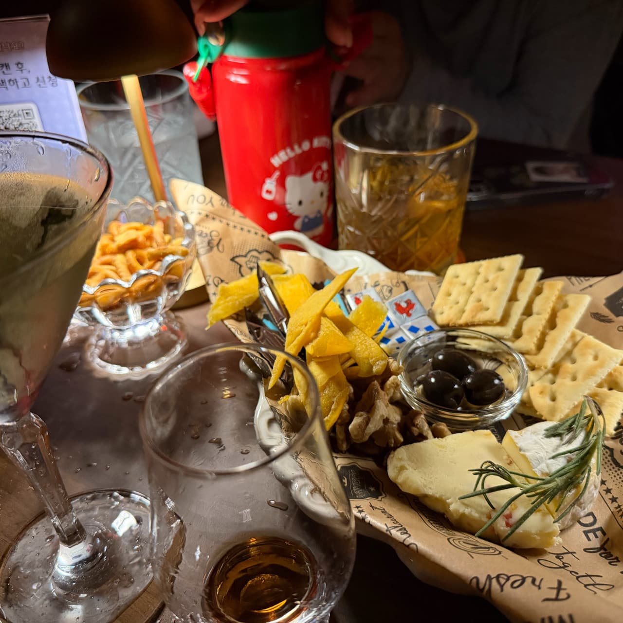 대전광역시 유성구 블렌딩바 대전혼술바 봉명점 바(Bar) 다찌석 조명 아래 치즈와 견과류 안주 플레이트와 위스키 잔이 놓인 1인 혼술 상황