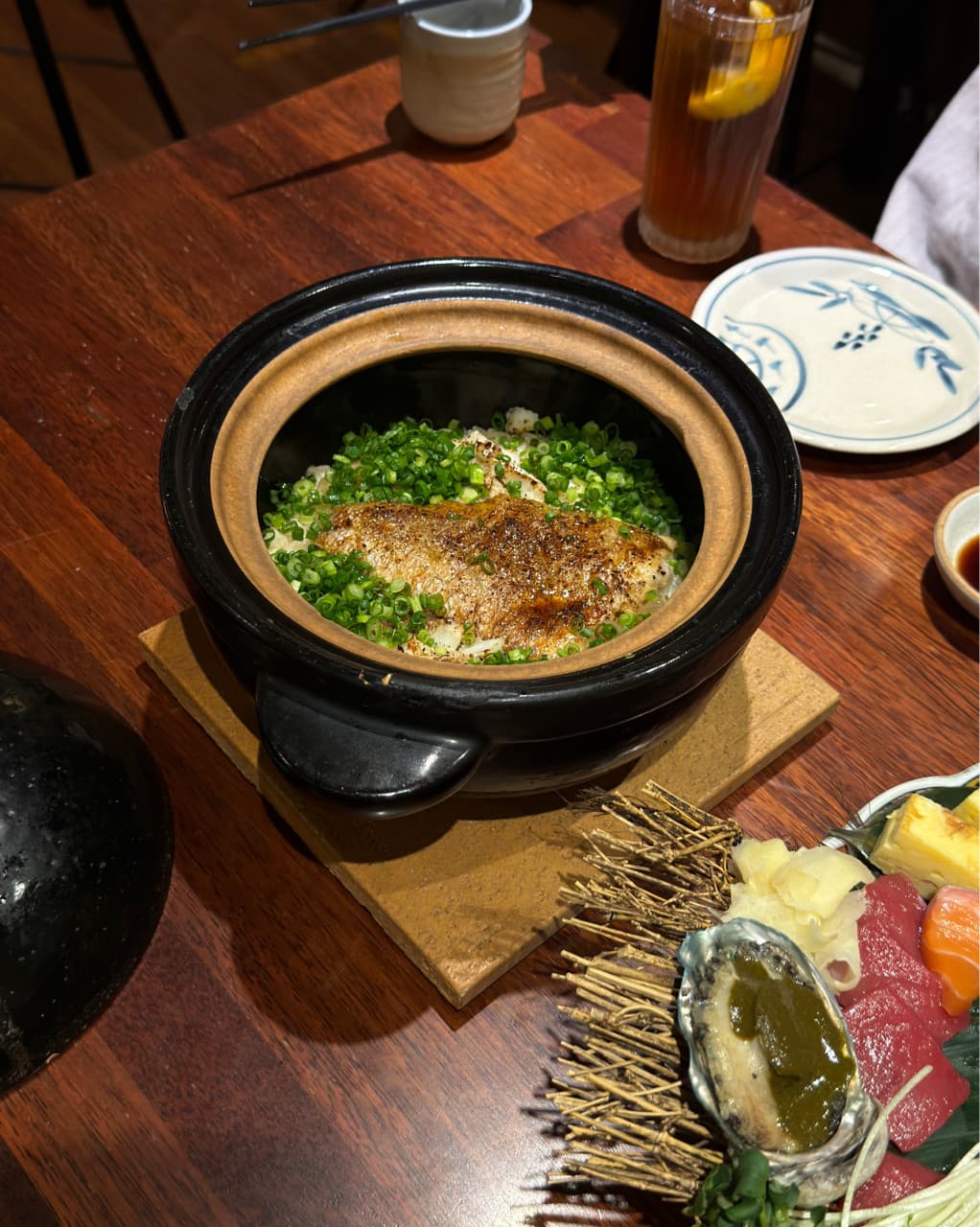 대전광역시 서구 이자카야 천구네 대전의 다찌석. 조명 아래 1인 혼술로 차려진 생선 솥밥과 모둠 사시미, 하이볼. 목재 테이블 위 음식의 질감과 혼자 식사하는 상황.