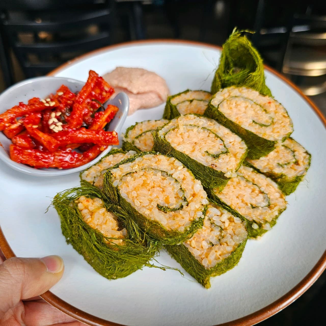 대전광역시 서구 화목식탁 대전 요리주점 다찌석에 차려진 1인 메뉴 감태말이. 실내 조명 아래 초록색 감태 질감과 명란마요, 빨간 무침이 대비를 이루는 혼술 상황.