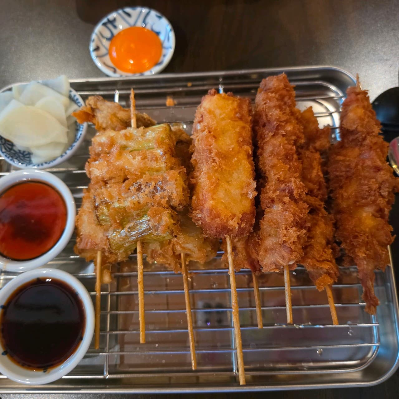 대전광역시 서구 야키토리동작 대전가수원점 이자카야 다찌석에서 즐기는 혼술. 바삭한 질감의 모둠 꼬치 튀김과 노른자 소스가 차려진 1인 테이블 상황.