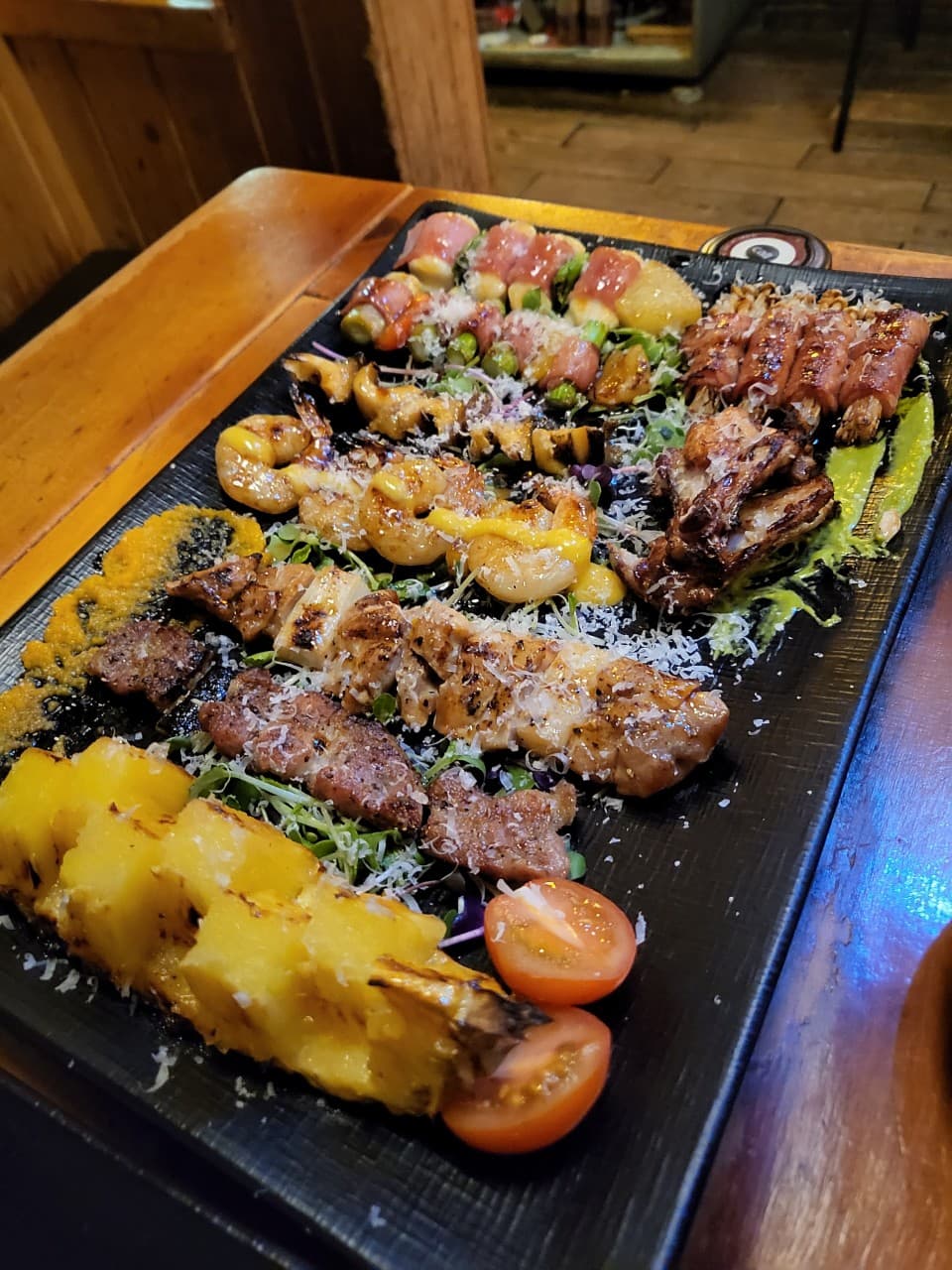 대전광역시 중구 해마직화구이 대전 이자카야 다찌석 위 직화 꼬치구이와 구운 파인애플이 담긴 1인 메뉴. 노란 조명 아래 육즙이 서린 고기와 새우 질감이 드러나는 혼술 환경.