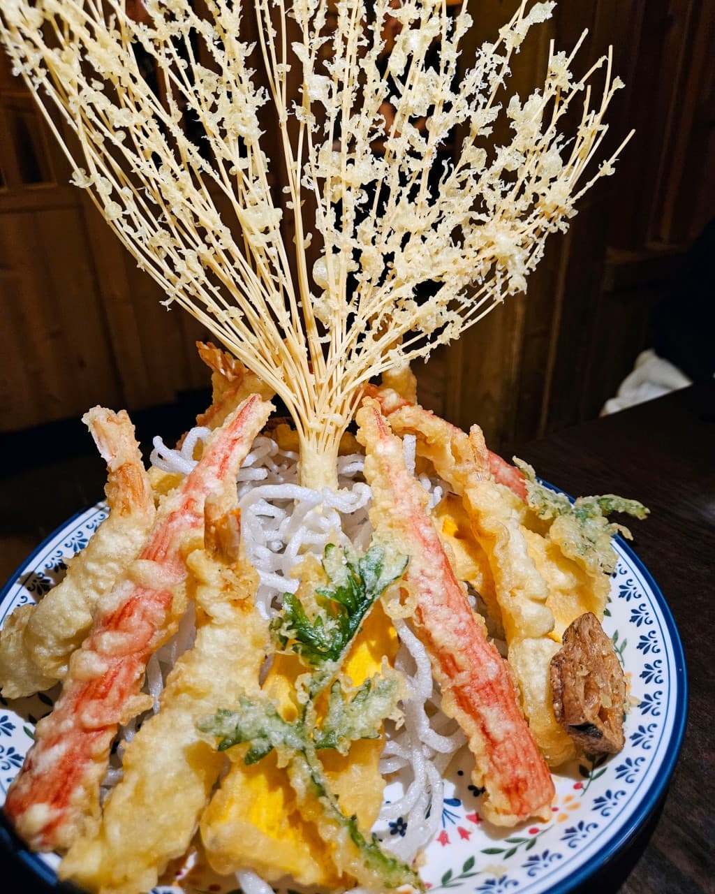대전광역시 중구 해마직화구이 대전 이자카야 다찌석. 바삭한 새우와 단호박 튀김 위로 부채꼴 면 튀김을 세운 1인 안주가 조명 아래 나무 테이블에 차려진 상황.