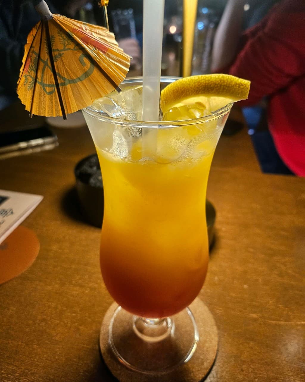 전남광주통합특별시 목포시 술결 목포혼술바 전남 바(Bar) - 다찌석 위 종이 우산과 레몬을 곁들인 오렌지색 칵테일로 즐기는 1인 혼술