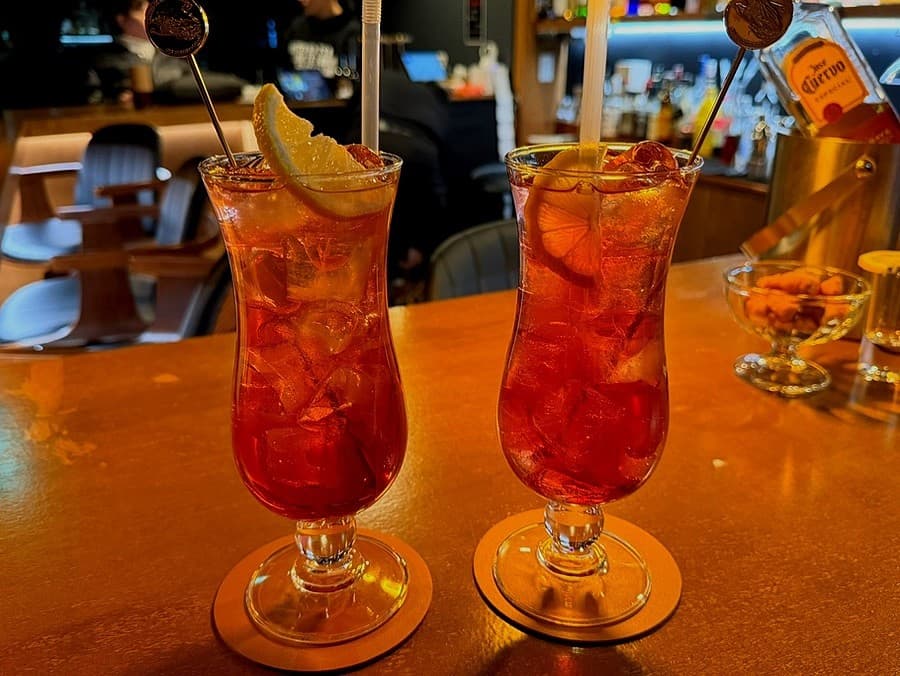 전남광주통합특별시 목포시 술결 목포혼술바 전남 바(Bar) 다찌석. 주황색 조명 아래 레몬 조각이 든 붉은 하이볼과 투명한 얼음이 담긴 혼술 테이블.