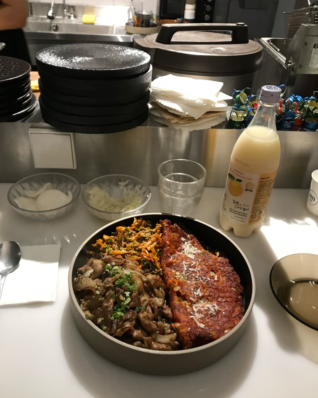 경상북도 경주시 요리주점 점점 경북 다찌석 혼술. 밝은 조명 아래 유자 막걸리와 고기 볶음, 전이 담긴 1인 메뉴가 놓인 흰색 카운터 테이블.
