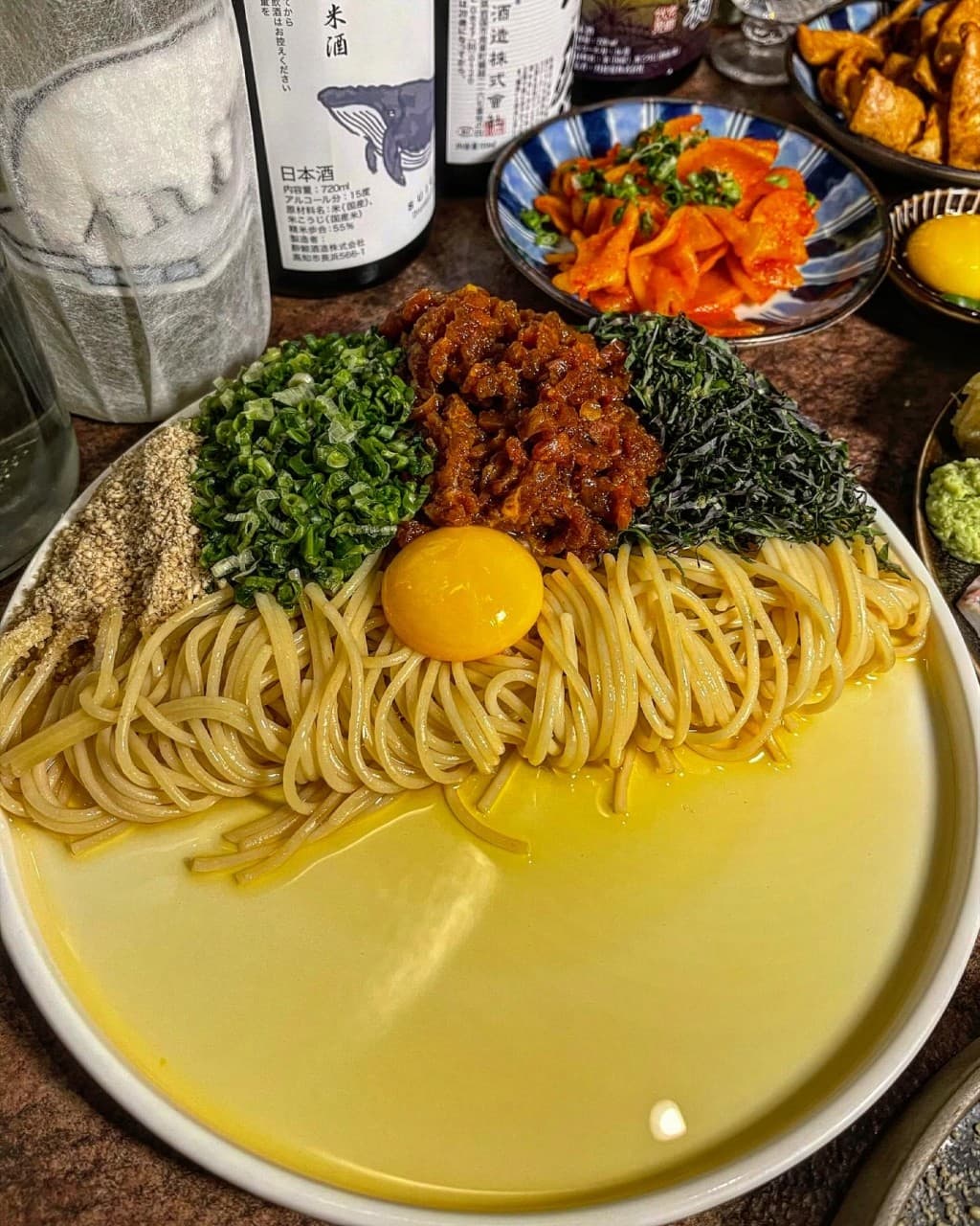 경상북도 경주시 샷타 경북 이자카야 다찌석 조명 아래 차려진 마제소바. 노란 노른자와 다진 고기, 파 고명이 올라간 면 요리와 사케병이 놓인 1인 혼술 상차림.