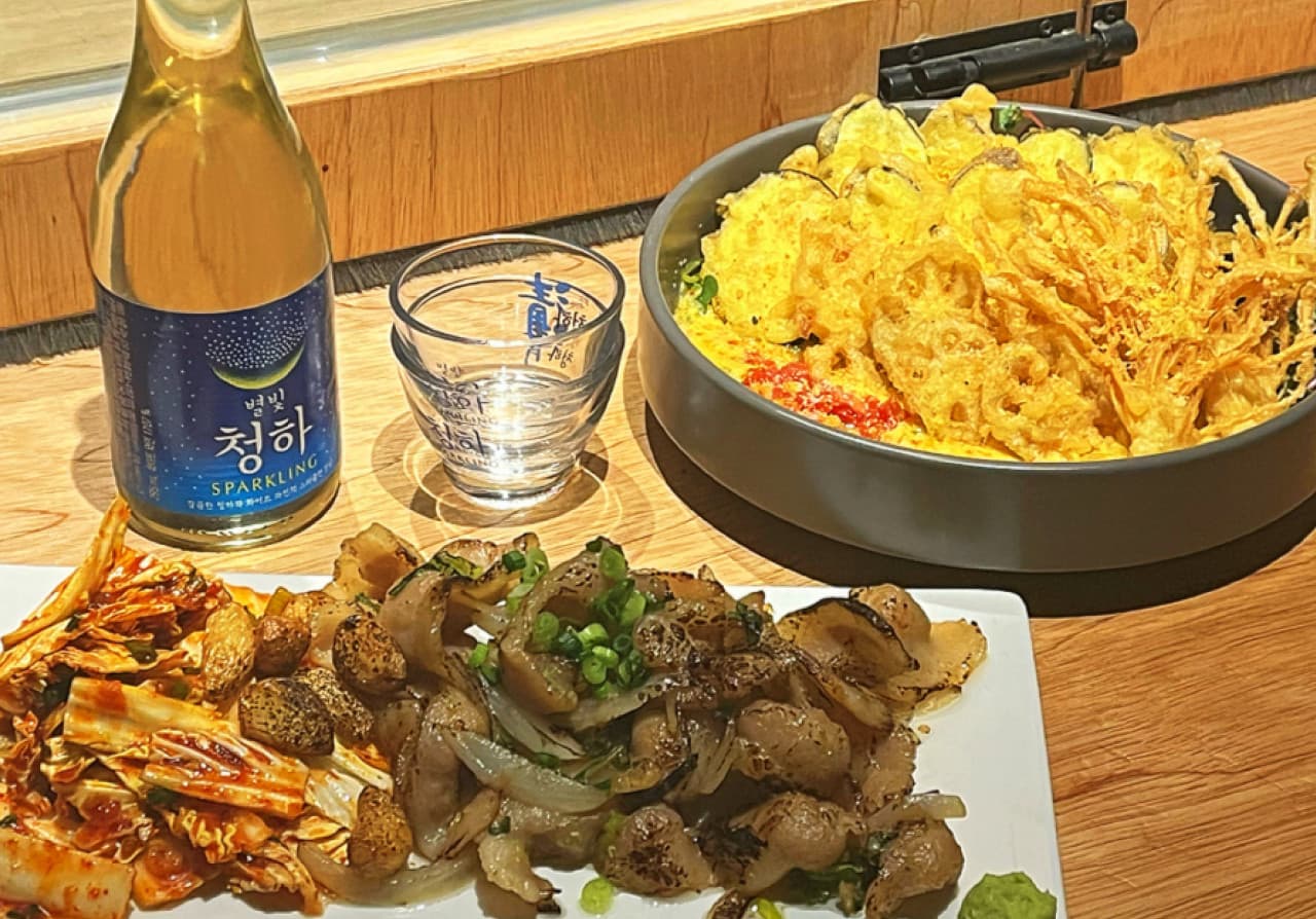 경상북도 경주시 이자카야 샷타 경북의 나무 다찌석에서 즐기는 혼술. 별빛 청하와 바삭한 튀김, 노릇한 구이 요리가 조명 아래 차려진 1인 상차림.