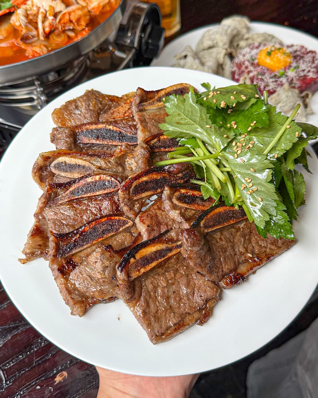 경기도 화성시 식사가되는 술집 양심 동탄점 경기 요리주점 - 다찌석에서 즐기는 1인 혼술 상차림으로 윤기 나는 LA 갈비와 참나물, 전골과 육회가 차려진 모습