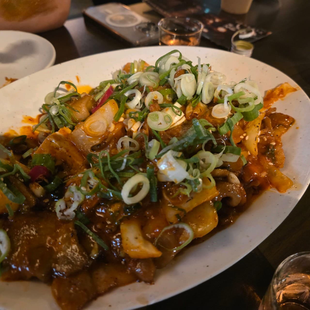 경기도 화성시 요리주점 식사가되는 술집 양심 동탄점 경기 - 조명 아래 1인 혼술 다찌석과 대파를 듬뿍 올린 윤기 나는 고기 요리