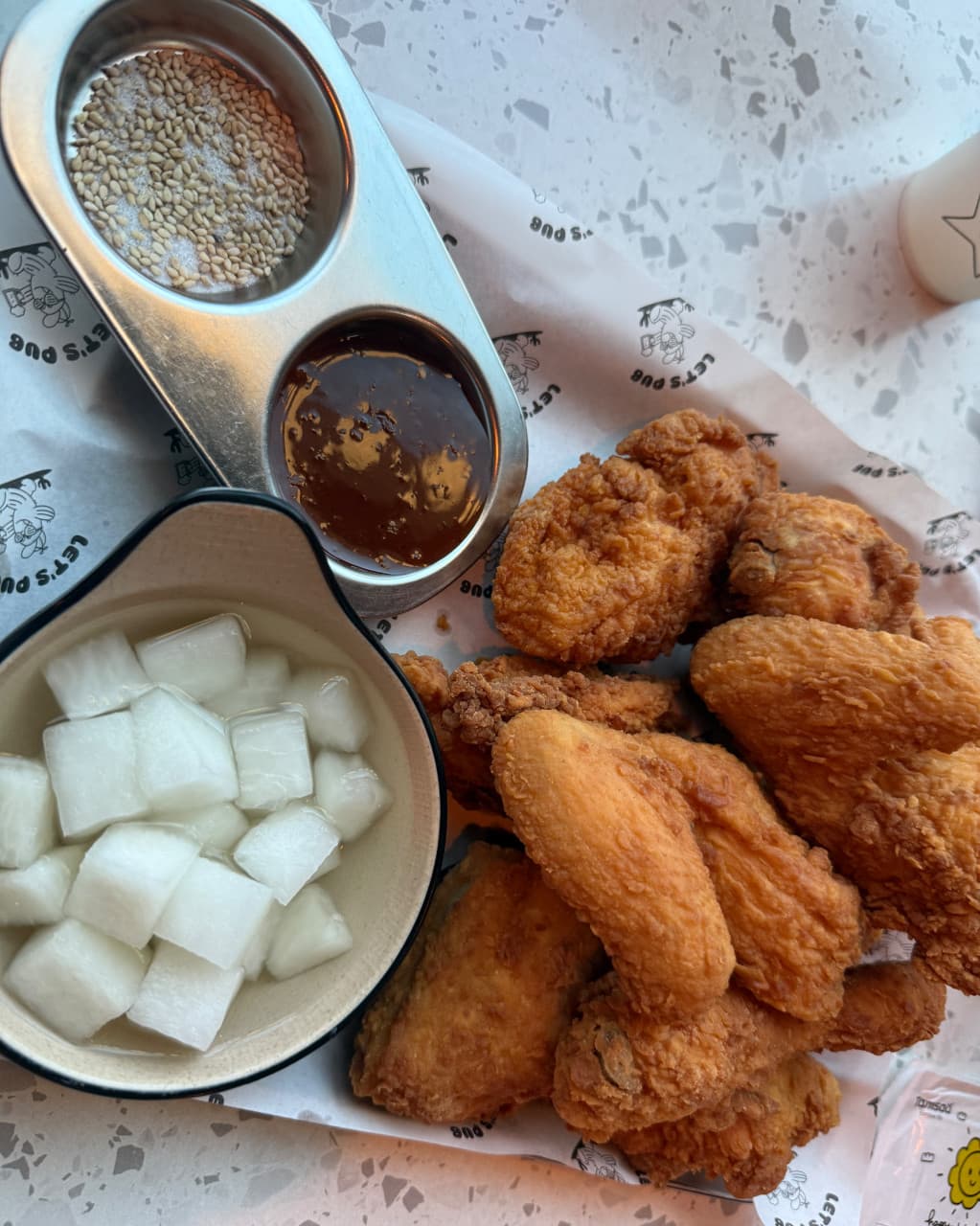 경기도 파주시 요리주점 피맥당x레츠펍 파주야당본점 경기 혼술 - 바삭한 치킨과 소스, 치킨무가 차려진 대리석 테이블 1인 좌석