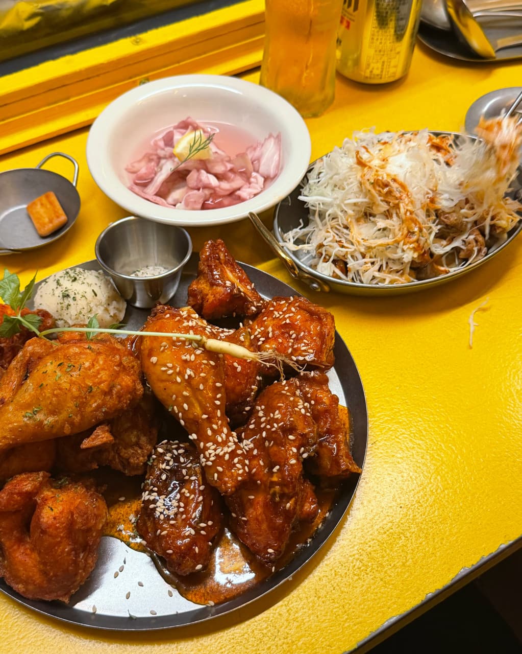 경기도 성남시 요리주점 일편닭심 판교본점 경기 노란 다찌석 위 윤기 나는 양념 치킨과 아삭한 양배추 샐러드. 하이볼 한 잔과 함께하는 1인 식사 구성